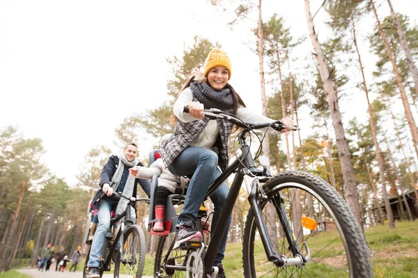 Ung familj i varma kläder cykling i höst park — Stockfoto