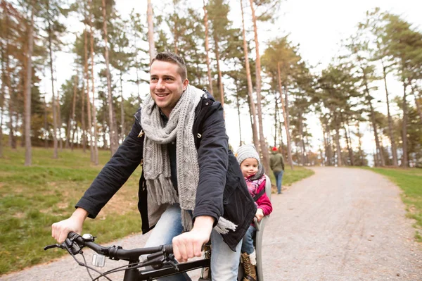Young father and daughter together on bicycle in autumn park — Stock Photo, Image