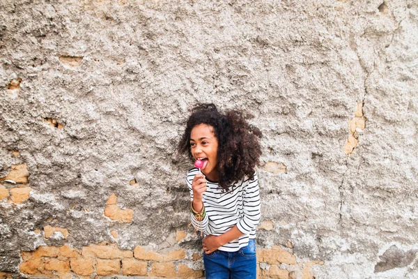 非洲裔美国女孩在混凝土墙上的条纹 t 恤. — 图库照片