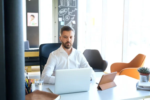 Affärsman på skrivbord med laptop i hans kontor. — Stockfoto