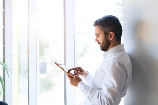 Hipster-Geschäftsmann arbeitet im Büro am Tablet. — Stockfoto