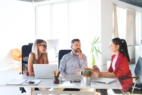 Three business people in the office talking together. — Stock Photo, Image