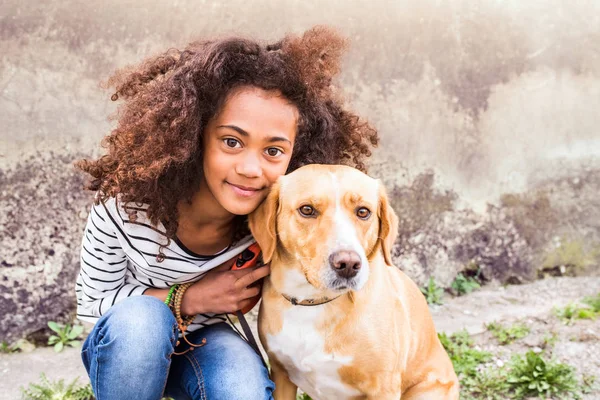 Chica afroamericana con su perro contra pared de hormigón . —  Fotos de Stock