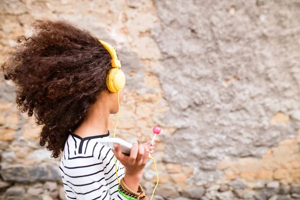 Piękna dziewczyna Afryki amerykański z inteligentnych telefonów i słuchawki. — Zdjęcie stockowe