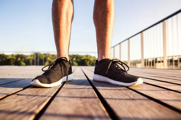 Gambe di corridore irriconoscibile in piedi su un ponte di legno . — Foto Stock