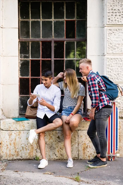 Grupo de estudantes na frente da universidade com telefone inteligente . — Fotografia de Stock