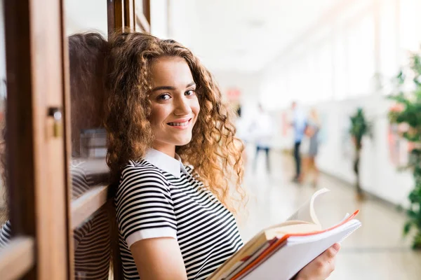 Tienermeisje met laptops in high school hal tijdens pauze. — Stockfoto