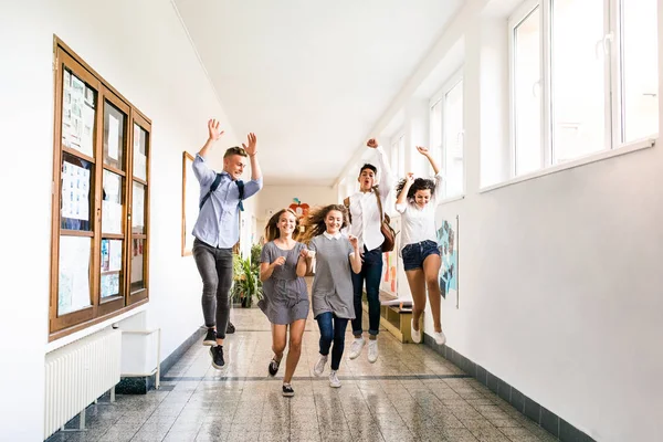Adolescentes en la sala de la escuela secundaria saltando alto . —  Fotos de Stock