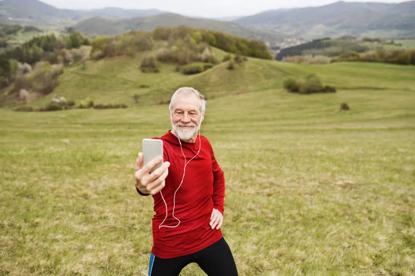 Активный старший бегун в природе делает селфи со смартфоном . — стоковое фото