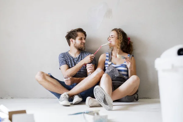 Giovane coppia innamorata pittura pareti nella loro nuova casa . — Foto Stock