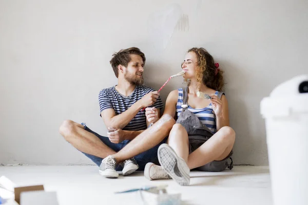 Jovem casal apaixonado pintura paredes em sua nova casa . — Fotografia de Stock