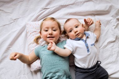 Sevimli küçük kız kardeşini yatakta yatarken ile.