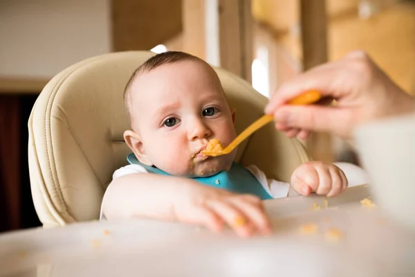 Mère méconnaissable à la maison nourrissant son fils bébé . — Photo