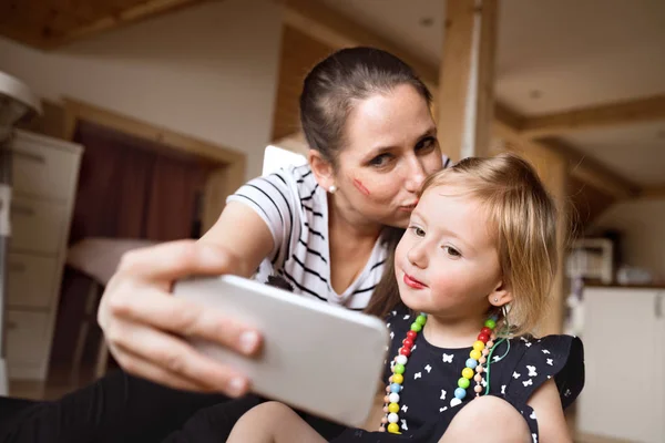 Hermosa madre e hija tomando selfie con teléfono inteligente . — Foto de Stock