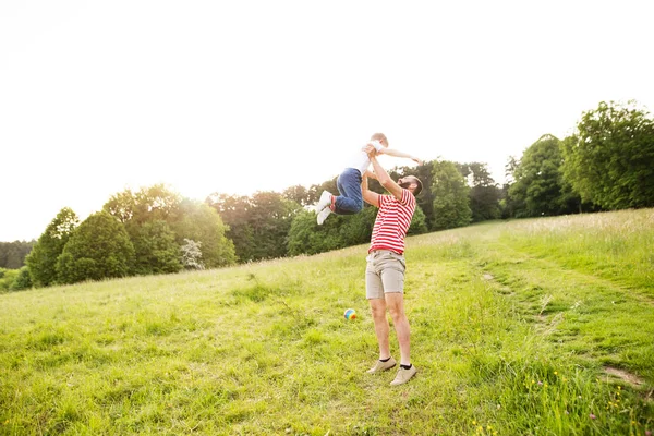 Hipster-Vater und kleiner Sohn auf der grünen Wiese. sonniger Sommertag. — Stockfoto