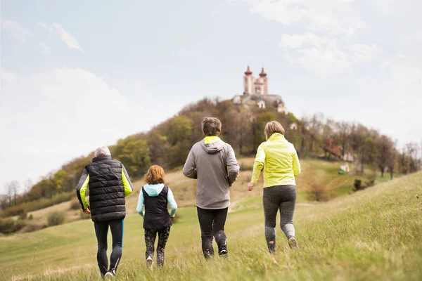 Group of seniors running outside on the green hills. — Stock Photo, Image
