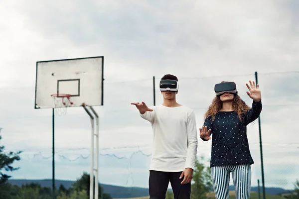 Atractivos adolescentes en el patio de recreo con gafas VR . — Foto de Stock