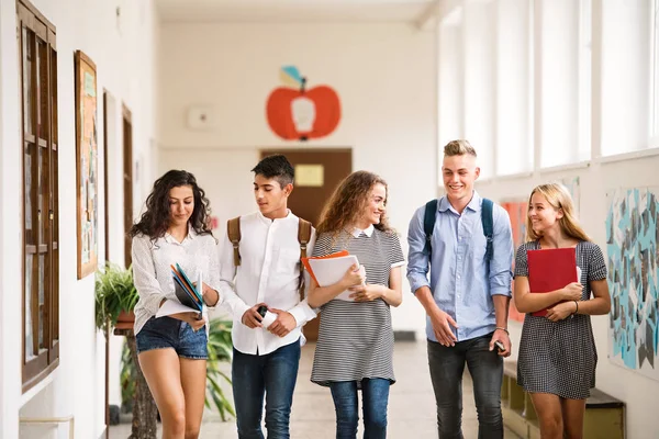 Εφηβική φοιτητές περπάτημα σε υψηλή σχολική αίθουσα, μιλάμε. — Φωτογραφία Αρχείου