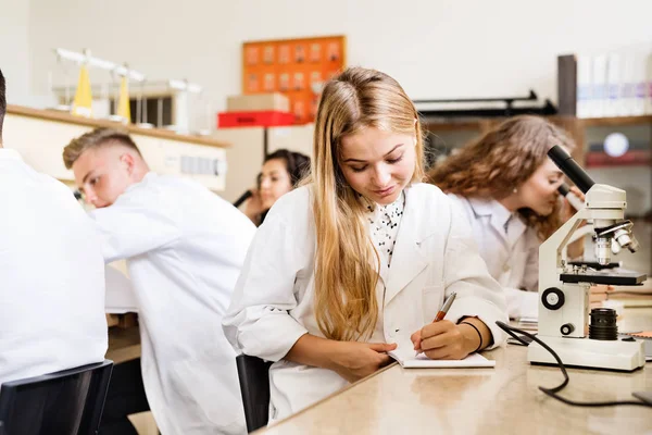 Estudante do ensino médio com microscópios em laboratório . — Fotografia de Stock
