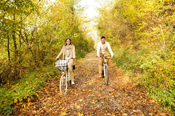 Junges Paar in warmer Kleidung radelt im Herbstpark. — Stockfoto