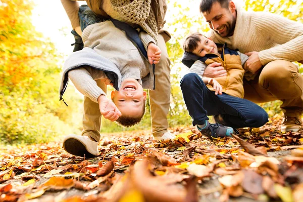 Bella giovane famiglia in una passeggiata nella foresta autunnale . — Foto Stock