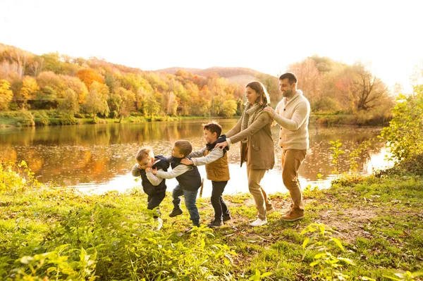 Bela família jovem em um passeio na floresta de outono . — Fotografia de Stock