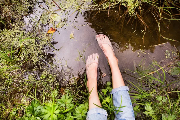 호수에 앉아 인식할 수 없는 여자의 발. — 스톡 사진