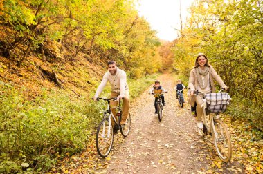 Genç aile içinde sıcak giysiler sonbahar parkta Bisiklete binme