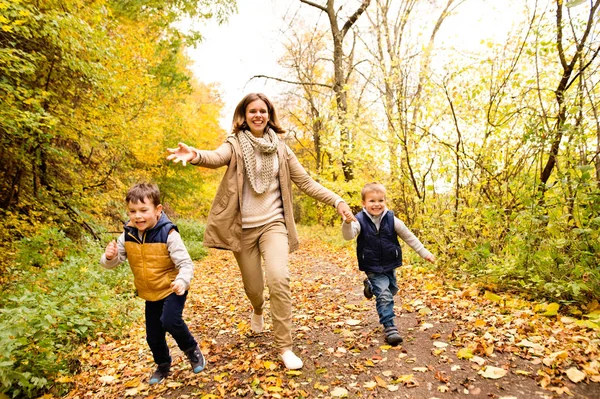 Sonbahar ormandaki oğulları ile güzel annem. — Stok fotoğraf
