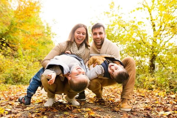 Piękna młoda rodzina na spacerze w lesie jesienią. — Zdjęcie stockowe