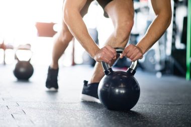 Tanınmayan uygun adam gönderme yapıyor spor salonunda ups kettlebells üzerinde