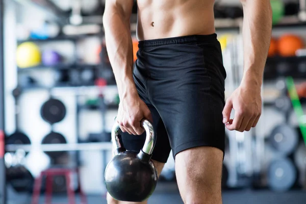 Tanınmayan genç adam kettlebell ile egzersiz spor salonunda yerleştirmek. — Stok fotoğraf