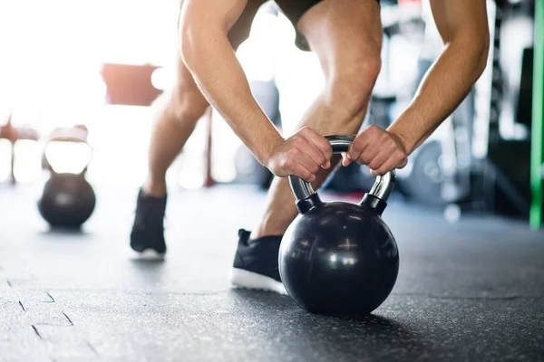 Onherkenbaar passen man in de sportschool doet push ups op kettlebells — Stockfoto
