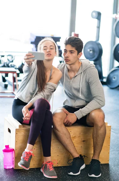 Fit casal no moderno ginásio crossfit com smartphone . — Fotografia de Stock