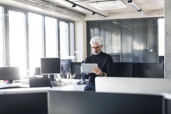 Rijpe zakenman met tablet in het kantoor. — Stockfoto