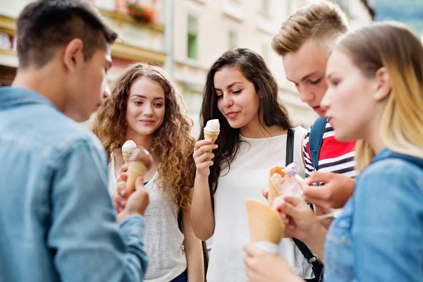 Aantrekkelijke teenage studenten in de stad eten van ijs. — Stockfoto