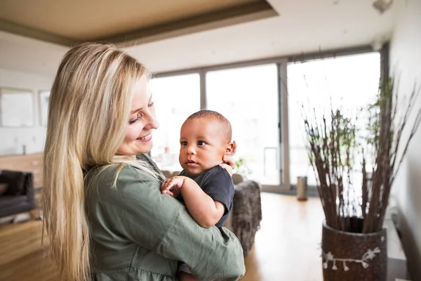 Gyönyörű fiatal anya otthon a kis baby boy. — Stock Fotó