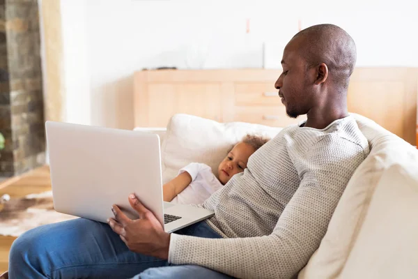 Afro-amerykański ojca z córeczką w domu trzymając laptop — Zdjęcie stockowe