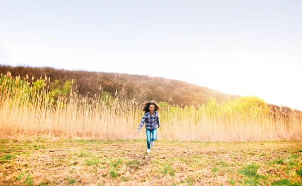 Afroamericano ragazza in camicia a quadri all'aperto in campo . — Foto Stock