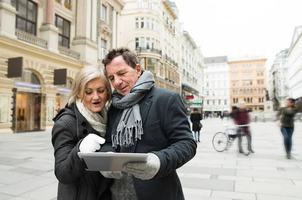 Belo casal sênior com tablet em um passeio no centro da cidade . — Fotografia de Stock