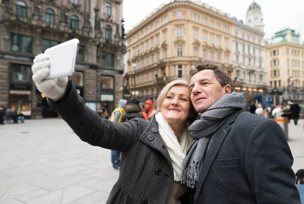 Schönes Senioren-Paar macht Selfie beim Spaziergang in der Innenstadt. — Stockfoto