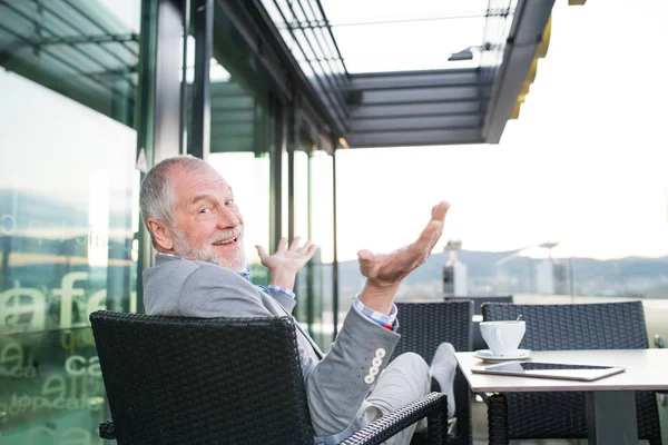 Uomo d'affari anziano con un tablet nel caffè sul tetto — Foto Stock