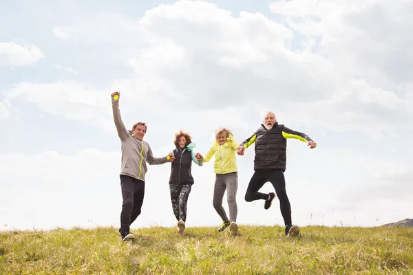 Grupo de corredores senior al aire libre, descansando, tomados de la mano . — Foto de Stock