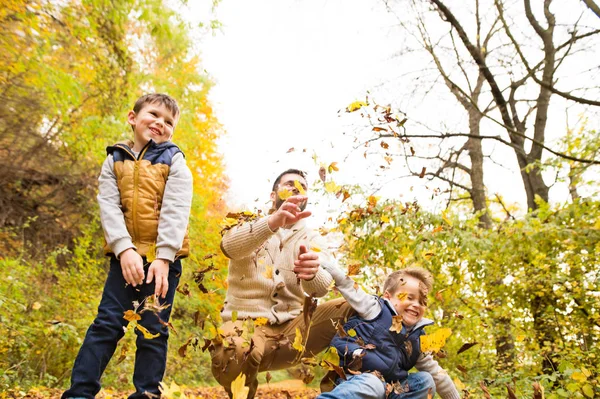 Giovane padre con i suoi figli nella foresta autunnale . — Foto Stock