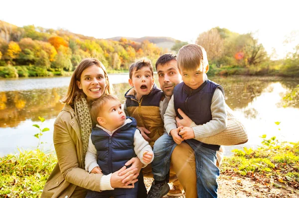 Bela família jovem em um passeio na floresta de outono . — Fotografia de Stock