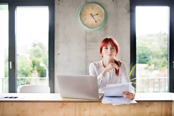 Femme d'affaires avec ordinateur portable dans son bureau . — Photo
