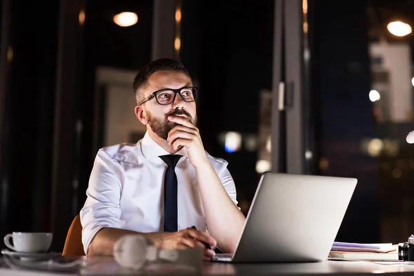 Homme d'affaires dans le bureau la nuit travaillant tard. — Photo