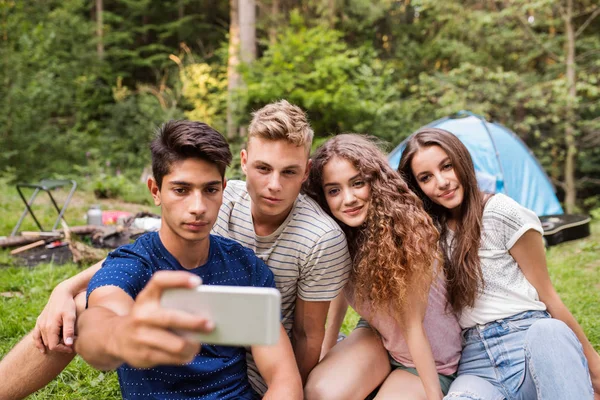 Tieners voor tent kamperen in het bos. — Stockfoto