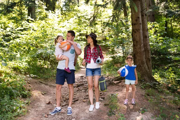 Schöne junge Familie mit Töchtern beim Zelten im Wald. — Stockfoto