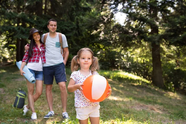 Schöne junge Familie mit Tochter campiert im Wald. — Stockfoto